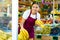 Young girl employees in uniform lay out and selling banana in grocery shop