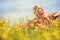 Young girl enjoy in blooming yellow field