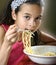 Young girl enjoying a bowl of pasta