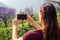 Young girl enjoying a good morning taking picture photo on camera of phone in tea plantations in India Munnar Kerala