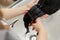 Young girl enjoys hair care in a beauty salon. The hairdresser washes the clients girls hair, applies a moisturizing oil