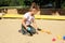 Young girl enjoys in the sandbox