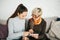 A young girl explains to an elderly woman how to use a tablet or shows some application or teaches you how to use a