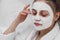 Young girl with face mask. skin care. Young beautiful girl relaxing with facial masks on over white background