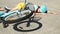 Young girl fallen of a bicycle laying down beside her bike unconscious on paved road