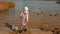 Young girl feeding ducks on lake in autumn, rear view