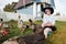 A young girl feeds domestic birds, ducks, hens, geese, turkeys in the yard of a rural house.