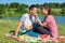 Young girl feeds a man on a picnic at the lake