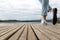 Young girl feet with shoes and blue jeans on a wooden pier