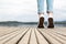 Young girl feet with shoes and blue jeans on a wooden pier tiptoed