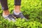 Young girl feet in sport shoes sneakers on green grass on meadow