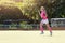 Young girl field hockey player running on pitch