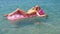 Young girl floating on a mattress in the sea