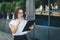 Young girl with folders for papers and a cup of coffee is standing on the city street. Business lady looking check list