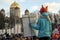 Young girl in fox mask hold poster in her hand and look at the church