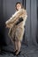 A young girl in a fur coat with a cloak with a handbag and an evening dress glamorous