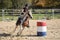 Young girl galloping around a barrel during a barrel race