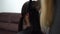 Young girl gets haircut from hairdresser at home, long black hair, from behind with copy space
