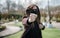 Young girl giving punch on unfocused background. Aggressive girl in a medical mask and glasses attacks