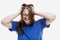 A young girl with glasses holds his head and laughs. A vivid manifestation of emotions. White background