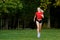 A young girl goes in for sports outdoors. woman in shorts and red t-shirt runs in nature