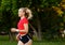 A young girl goes in for sports outdoors. woman in shorts and red t-shirt runs in nature