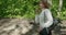 Young girl goes for yoga training in nature calm mood. Woman relaxes in a city nature park. Slow motion