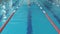 Young girl in goggles and cap swimming back crawl stroke style in the blue water pool