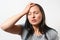 Young girl grabs her head with her hand and depicts a severe headache. On white background