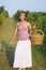 Young girl in grape harvest with big wicker basket for storing g