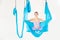 Young girl gymnast in sportswear doing stretching on blue hammock in white studio. Concept aero fly yoga