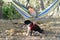 Young Girl in a Hammock Playing with Dog