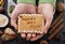 Young girl hands hold gingerbread biscuit with happy new year text and white icing