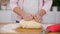 Young girl hands knead dough on wooden board in the kitchen