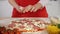 Young girl hands place mushroom slices and chunks on pizza prepared at home