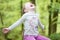 Young girl happy smiling picking bluebell flowers outside in spring summer forest woodland