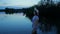 Young girl with a hat in a lake on her knees admires nature.