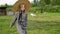 Young girl in hat walking on rural barnyard. Rustic girl walking on livestock in summer countryside. Teen model on