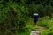 Young girl with heavy backpack hiking on lush green paths in Romanian mountains