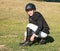 Young girl in helmet preparing spurs before showjumping competition