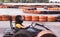 A young girl in a helmet rushes on a high-speed go-kart on a race track, against the background of blurred wheel guards, side view