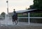 Young girl with helmet trains horseback riding