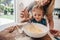 Young girl with her mother mixing batter at home