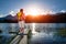 Young girl in hike on the small pier of an alpine lake