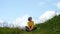 Young girl hiker sitting and resting on a grassy hill