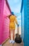 Young girl from his back with an acoustic guitar in the colorful huts of the beach. Freedom, youth, future, fun concept