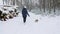 Young girl with his beagle dog are walks through a snowy winter forest. Outdoor walking. Mans best friend. Slow motion