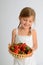 Young girl holding basket of red strawberries