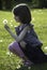 A young girl is holding a dandelion she has just picked