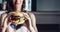 Young girl holding in female hands fast food burger, american unhealthy calories meal on background, mockup with copy space